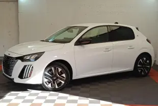 Peugeot 208 électrique blanche vue de profil côté gauche dans un garage avec jantes distinctives bicolores.