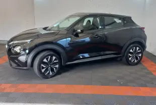 Nissan Juke noir vue de profil côté gauche, avec jantes noires et détails de carrosserie lisse dans un garage.