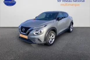 Nissan Juke gris clair vu en 3/4 avant droit, mettant en valeur ses phares ronds et sa calandre noire distinctive.