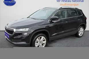 Vue 3/4 avant droite d’un Skoda Karoq noir 2025 avec jantes alu et barres de toit visibles.