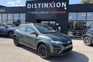 Vue 3/4 avant gauche d'une Dacia Sandero III Stepway 2025 vert cèdre avec jantes noires et coques de rétroviseur cuivrées.