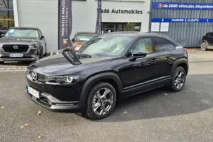 Vue 3/4 avant droite d'un Mazda MX-30 électrique noir, avec jantes alliage et sellerie Modern Confidence visible à travers les vitres.