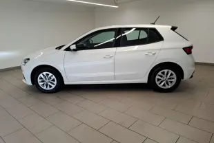 Vue latérale droite d'une Skoda Fabia blanche Candy 2023, finition Ambition, en intérieur sur sol carrelé.