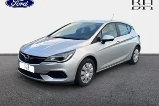 Opel Astra gris minéral vue 3/4 avant droit, avec jantes acier et calandre noire distinctive.
