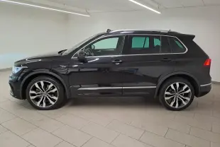 Vue de profil côté gauche d'un Volkswagen Tiguan 1.4 eHybrid noir intense nacré avec jantes 20'' Suzuka et attelage escamotable.