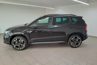 Vue de profil côté gauche d'un CUPRA Ateca 2024 noir magique avec jantes alliage distinctives en intérieur neutre.