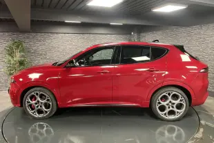 Alfa Romeo Tonale rouge vue de profil côté gauche, avec jantes alliage 20 pouces et étriers de frein rouges.