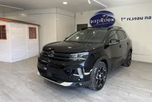 Vue 3/4 avant droit d'un Citroën C5 Aircross noir brillant avec jantes noires et détails chromés en showroom.