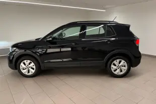 Volkswagen T-Cross 2024 noir intense vu de profil côté gauche dans un intérieur lumineux avec jantes argentées.