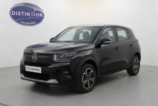 Vue 3/4 avant d'une Citroën C3 noire électrique 2025 avec jantes distinctives et calandre moderne.