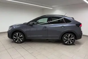 Vue de profil côté gauche du Volkswagen Taigo gris cendre avec jantes alliage 18 pouces en intérieur neutre.