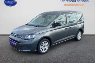Volkswagen Caddy gris indien en vue 3/4 avant droit, avec vitres teintées et jantes alliage.