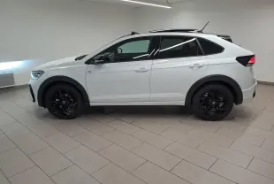 Vue de profil côté gauche d'un Volkswagen Taigo blanc pur avec toit noir et jantes noires en alliage.