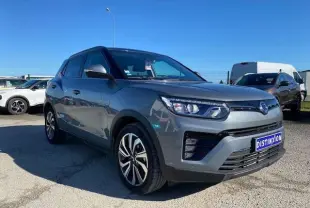 Ssangyong Tivoli gris foncé en vue 3/4 avant droit, avec jantes alliage et calandre moderne sous un ciel bleu.