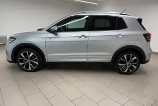 Profil côté gauche du Volkswagen T-Cross 1.5 TSI R-Line 2024 en peinture métallisée Reflet d'Argent avec jantes alliage noires et argent.