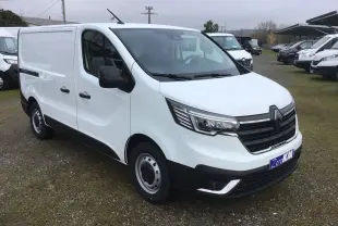 Vue 3/4 avant droit d’un Renault Trafic Fourgon blanc 2025 avec calandre noire et feux LED distinctifs.