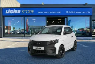 Vue 3/4 avant d'une Ligier JS50 Select blanc glacier avec calandre noire et jantes noires devant un showroom Ligier Store.