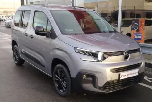Vue 3/4 avant droit du Citroën Berlingo gris acier 2025 avec phares LED et jantes noires brillantes.