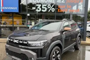 SUV Dacia Duster Extreme Hybrid 140 noir vu en 3/4 avant avec rétroviseurs couleur cuivre devant un concessionnaire