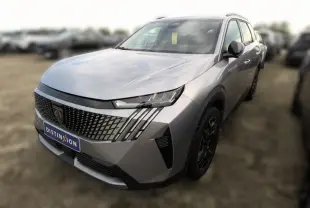 Peugeot 5008 Hybrid gris Artense en 3/4 avant droit, avec calandre distinctive et jantes noires stylées.