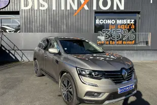 Renault Koleos gris 3/4 avant droit, mettant en valeur ses optiques LED et sa calandre noire brillante.
