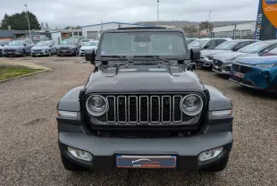 Vue de face du Jeep Wrangler noir avec calandre à sept fentes et phares ronds LED, sur parking extérieur.