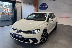 Volkswagen Polo 2024 blanche vue 3/4 avant en intérieur avec jantes alliage R-Line et calandre spécifique.
