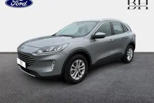 Ford Kuga gris Solar métallisé en vue 3/4 avant droit, avec jantes alu et barres de toit visibles.