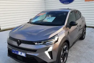 Vue 3/4 avant d’un Renault Captur gris Cassiopée 2025 avec feux LED et jantes bi-ton visibles sur parking.