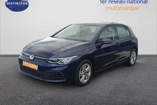Volkswagen Golf VIII bleu Atlantique métal vue 3/4 avant droit sur sol gris devant un mur blanc.