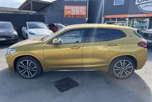 Profil côté gauche d'un BMW X2 jaune métallisé sDrive 18d M Sport avec jantes alliage 19 pouces et toit panoramique.
