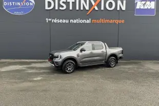Ford Ranger 2025 gris en vue de profil droit, pick-up Wildtrak avec jantes noires et logo rouge sur calandre.