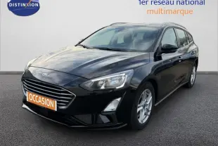 Ford Focus SW noire vue en 3/4 avant droit avec barres de toit et jantes alliage 16 pouces.