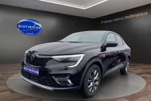 Renault Arkana noir vue 3/4 avant droit en intérieur, avec calandre distinctive et feux LED allumés.