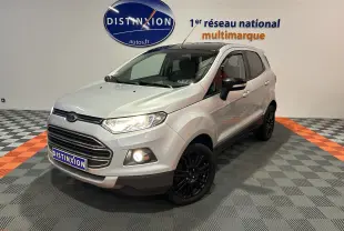 Ford EcoSport gris en 3/4 avant droit avec jantes noires et phares allumés dans un showroom