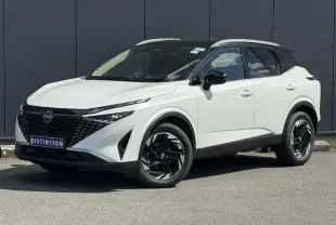 Nissan Qashqai blanc nacré avec toit noir, vu en 3/4 avant droit, jantes alliage noires et calandre distinctive.