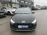 Vue avant d'une Hyundai i20 2025 noir Phantom Metal avec calandre hexagonale et phares LED allumés en extérieur.