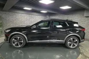 Vue de profil côté gauche du CUPRA Formentor noir avec jantes alliage et détails gris contrastants sur les bas de caisse.