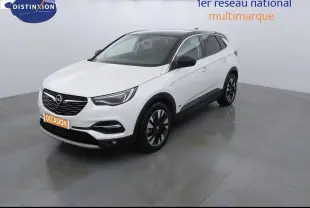 Opel Grandland X blanc nacré vu en 3/4 avant droit avec toit noir et jantes bicolores dans un studio lumineux