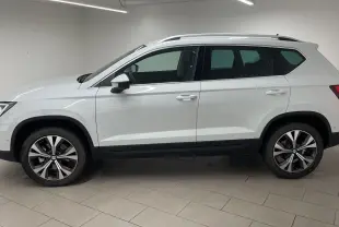 Profil droit du SUV SEAT Ateca blanc Nevada avec jantes alliage 18 pouces et toit équipé de barres de toit.
