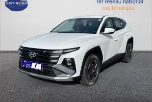 Hyundai Tucson blanc Atlas vu en 3/4 avant droit, avec calandre noire et jantes foncées distinctives.