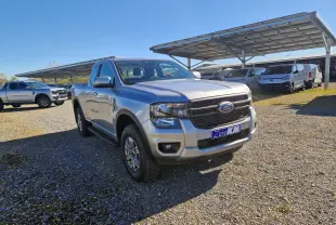 Ford Ranger Super Cabine 4x4 gris iconic vu en 3/4 avant droit sur un parking ensoleillé.
