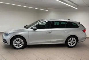 Vue latérale droite d'une Skoda Octavia Combi gris argent 2023 avec jantes alliage et feux arrière LED distinctifs.