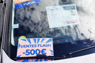 Vue avant rapprochée du pare-brise d’un Peugeot 5008 gris 2019 avec étiquettes diesel, 7 places et promotion -500€.