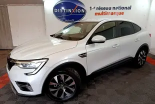 Renault Arkana blanc en 3/4 avant droit, SUV hybride avec jantes noires et phares LED allumés.