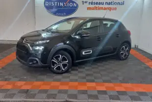 Citroën C3 noire vue de profil droit en intérieur, avec protections latérales blanches et jantes distinctives.