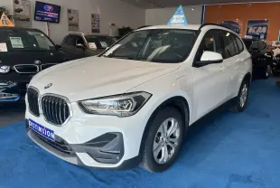 BMW X1 XDRIVE blanc alpin vu en 3/4 avant droit dans un showroom avec détails de calandre et phares LED visibles