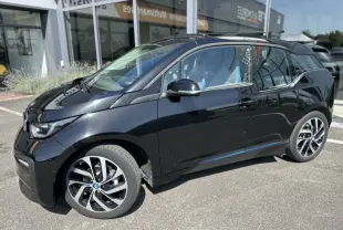 BMW i3 noire vue de profil côté gauche, mettant en valeur ses jantes distinctives et son design compact électrique.