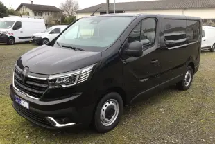 Vue 3/4 avant droite d’un Renault Trafic Fourgon noir 2025 avec calandre chromée et jantes acier.