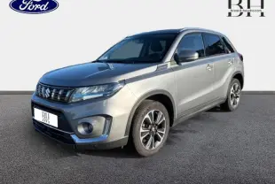 Suzuki Vitara 1.4 Boosterjet Hybrid gris Galactic, vue 3/4 avant avec jantes alu et calandre chromée.